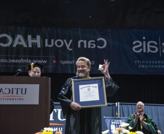 Dr. 在2024年的毕业典礼上，亚当·帕克拿着镶有镜框的克里萨fulli奖.